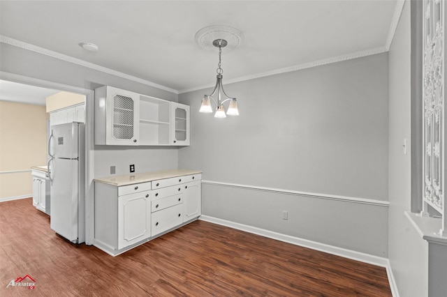 kitchen featuring dark hardwood / wood-style floors, pendant lighting, white cabinets, white refrigerator, and a chandelier