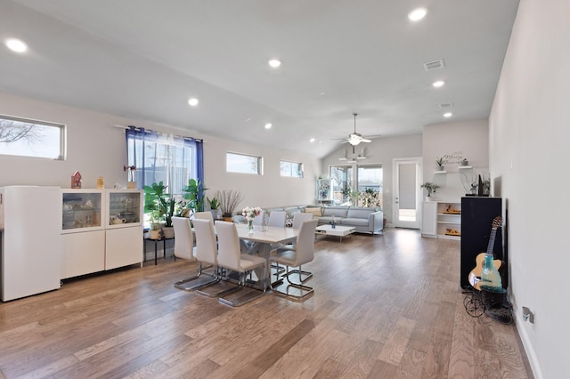 dining room featuring ceiling fan, light hardwood / wood-style floors, and lofted ceiling