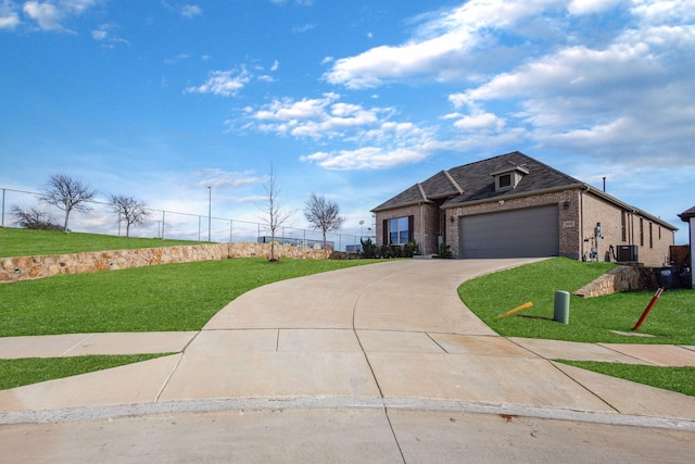 view of front of property featuring a garage, a front lawn, and central AC unit