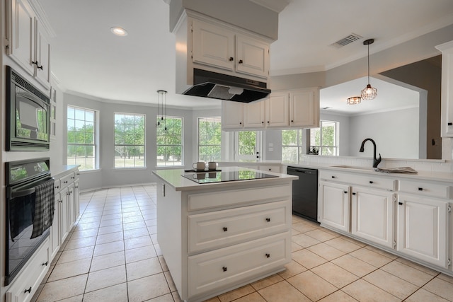 kitchen with light countertops, hanging light fixtures, white cabinets, under cabinet range hood, and black appliances