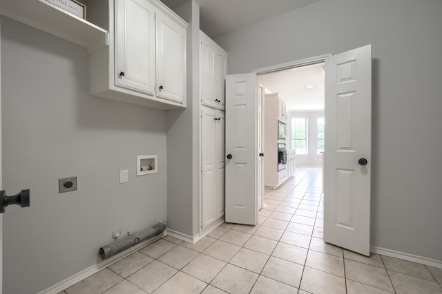laundry room with cabinet space, light tile patterned floors, hookup for a gas dryer, hookup for an electric dryer, and washer hookup