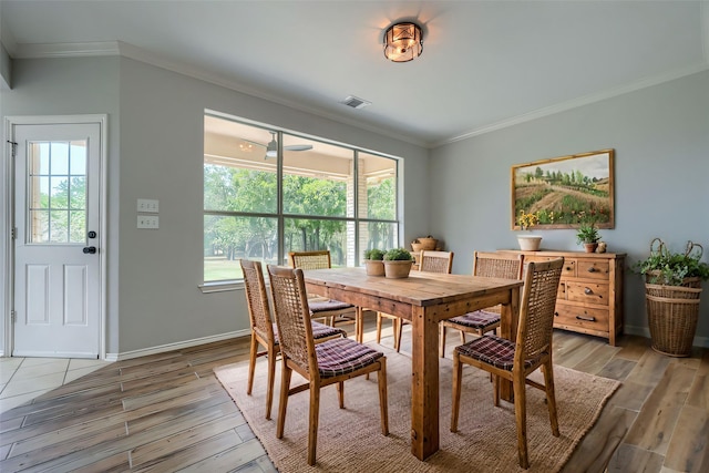 dining space featuring ornamental molding, a healthy amount of sunlight, and light wood finished floors