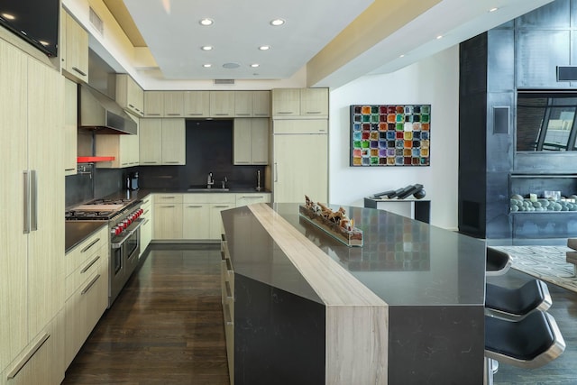 kitchen featuring double oven range, a large island, decorative backsplash, wall chimney range hood, and sink