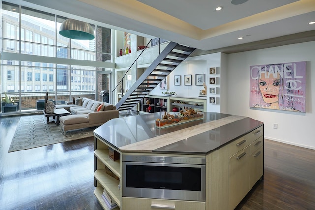 kitchen featuring a wall of windows, dark wood-type flooring, and a center island