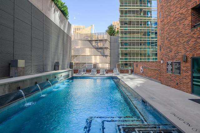 view of swimming pool with pool water feature