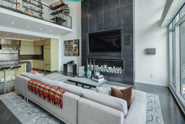 living room with dark wood-type flooring and a high ceiling