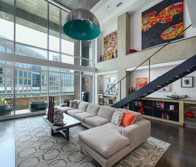 living room featuring wood-type flooring and a towering ceiling