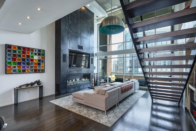 living room featuring dark hardwood / wood-style floors and a towering ceiling