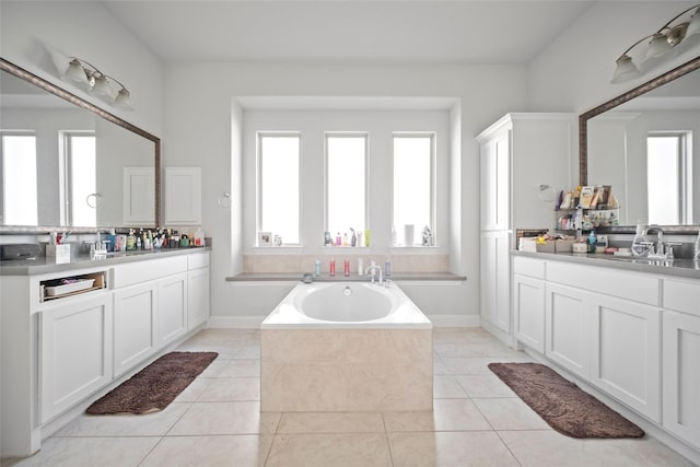 bathroom with tiled tub, tile patterned floors, and vanity