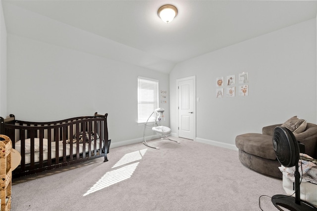 carpeted bedroom featuring lofted ceiling and a crib