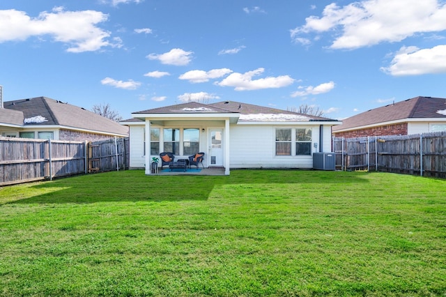 rear view of property featuring central AC unit, a patio, and a yard