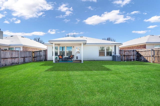 rear view of house with a patio area, central air condition unit, and a yard