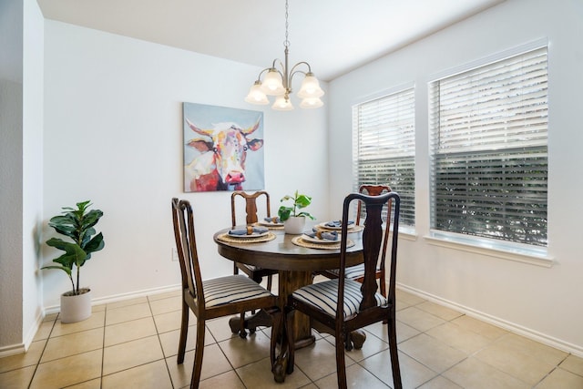 tiled dining room with a chandelier