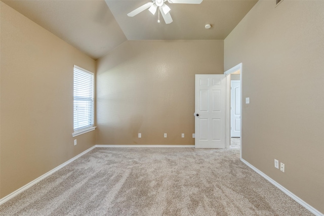 carpeted spare room with ceiling fan and lofted ceiling