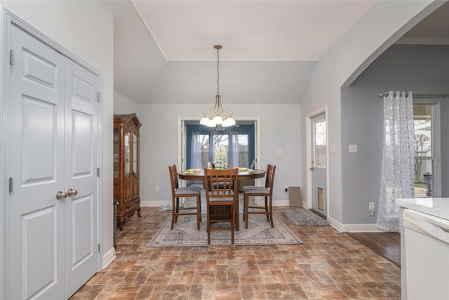 dining area featuring an inviting chandelier and vaulted ceiling