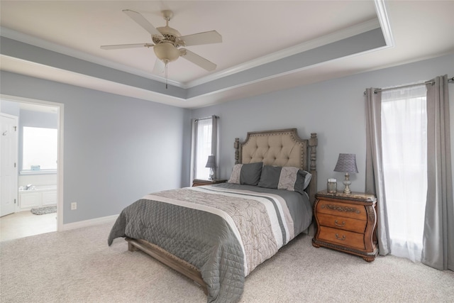 bedroom featuring ensuite bath, ornamental molding, a raised ceiling, ceiling fan, and light colored carpet