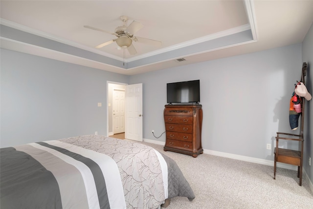 carpeted bedroom featuring ceiling fan, ornamental molding, and a raised ceiling