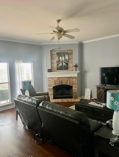 living room with hardwood / wood-style flooring, crown molding, and a fireplace