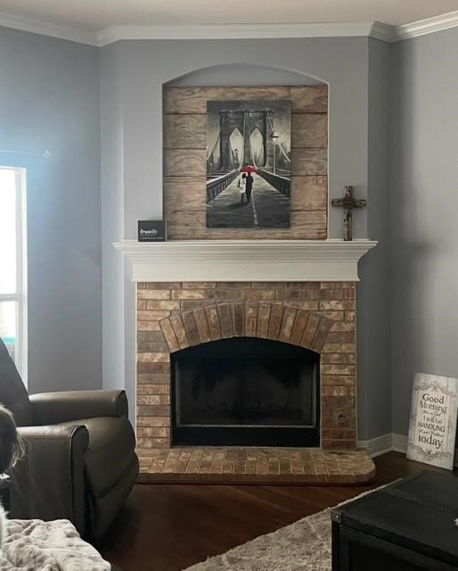 interior details with a brick fireplace, crown molding, and wood-type flooring