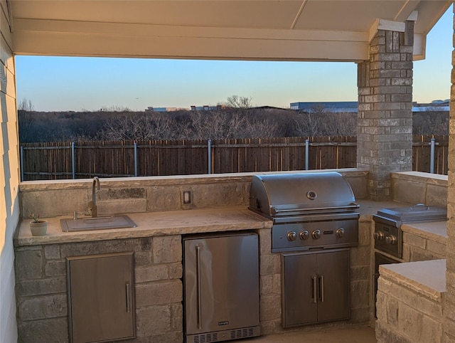 view of patio featuring an outdoor kitchen, sink, and area for grilling