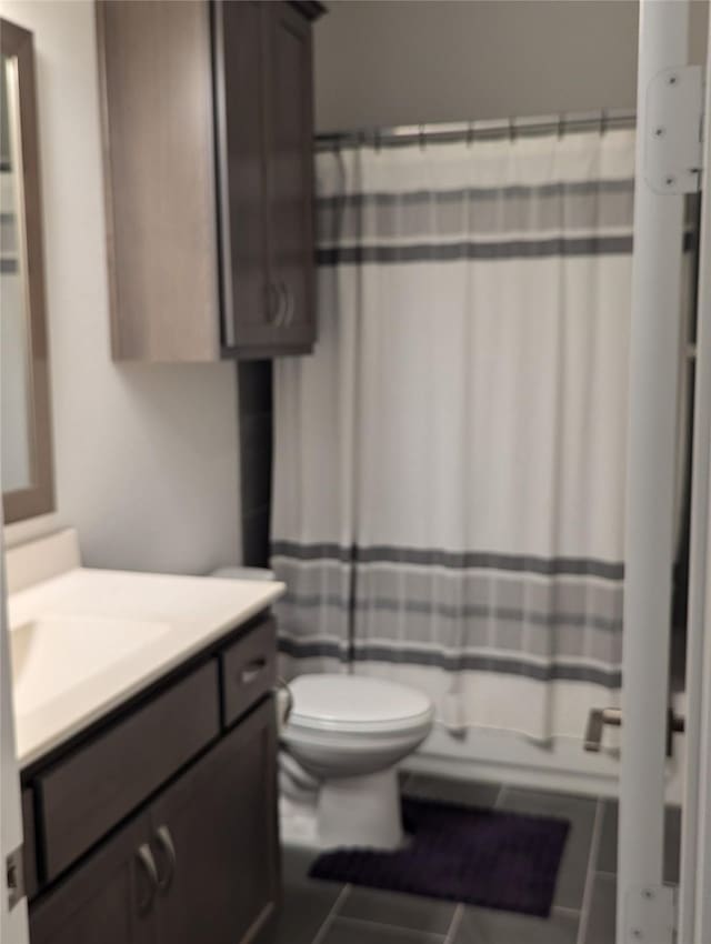 bathroom with toilet, vanity, tile patterned floors, and a shower with shower curtain