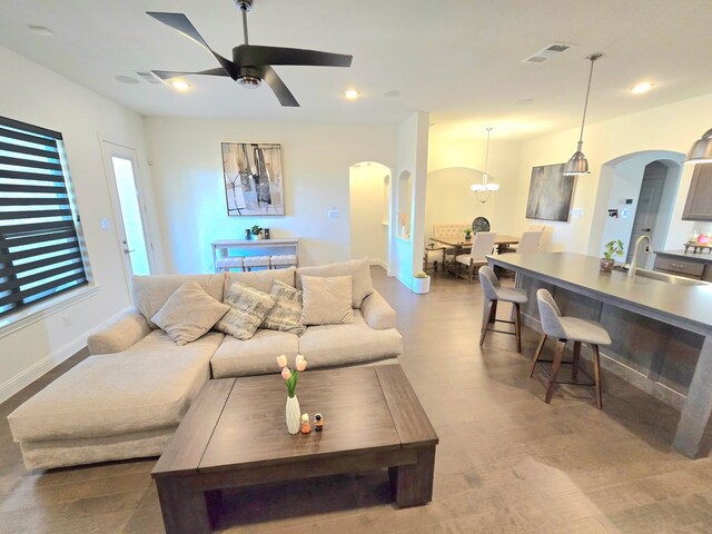 kitchen with sink, hanging light fixtures, stainless steel appliances, and a kitchen island with sink