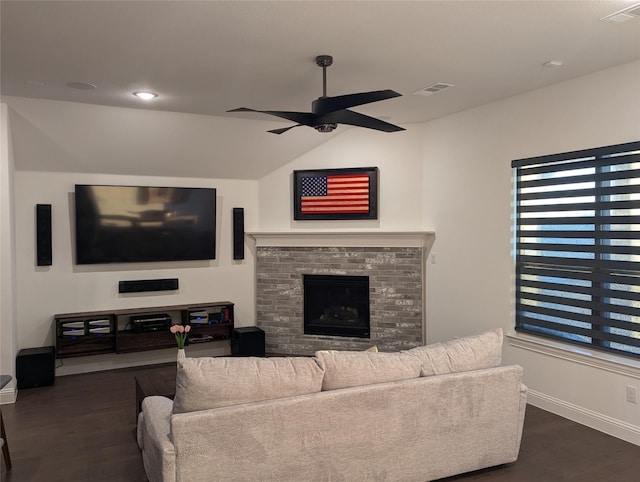 living room featuring ceiling fan, vaulted ceiling, dark hardwood / wood-style floors, and a fireplace