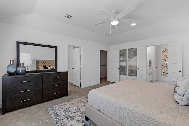 bedroom with ceiling fan, light carpet, ensuite bathroom, and lofted ceiling