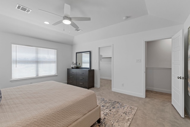 bedroom with a spacious closet, lofted ceiling, light carpet, a closet, and ceiling fan