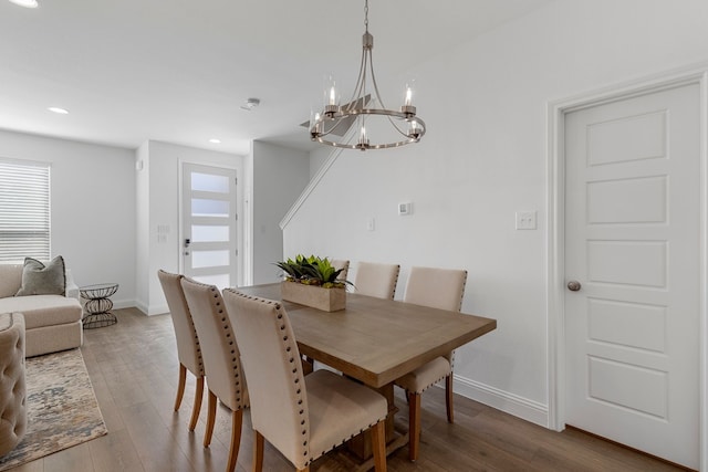 dining area with hardwood / wood-style floors and a chandelier