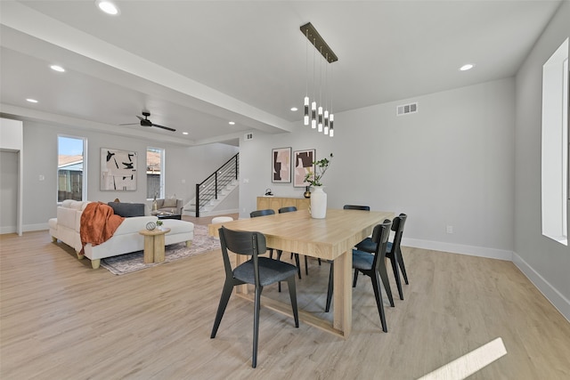 dining space with ceiling fan and light hardwood / wood-style flooring