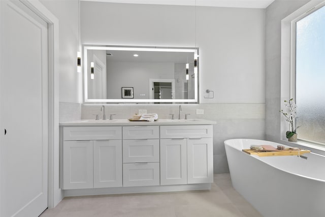 bathroom with a bath, tile patterned flooring, and vanity