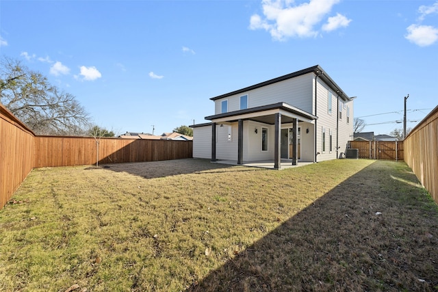 rear view of property featuring central AC unit, a yard, and a patio