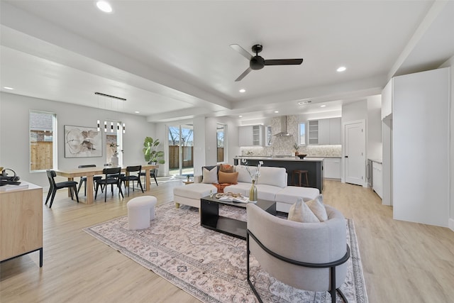 living room with ceiling fan and light hardwood / wood-style flooring