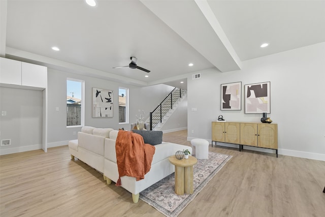 living room with light wood-type flooring, ceiling fan, and beam ceiling