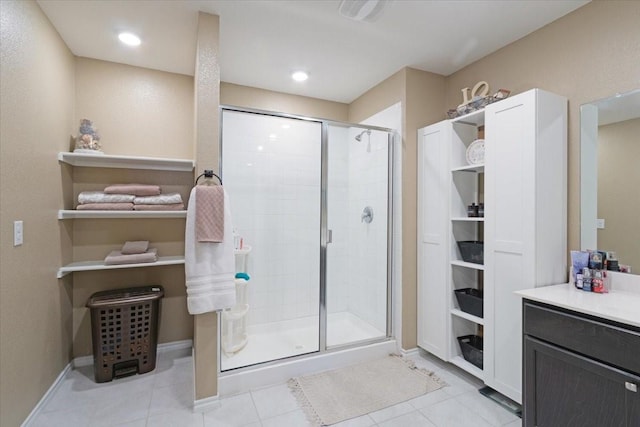 bathroom featuring a shower with shower door, tile patterned floors, and vanity