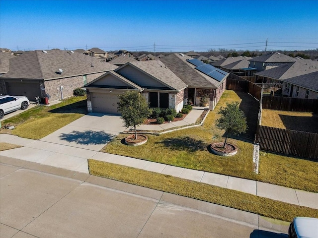 view of front of home with a front yard, a garage, and solar panels