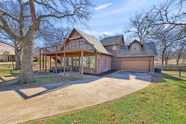 view of front of house featuring a garage, a front yard, and a deck