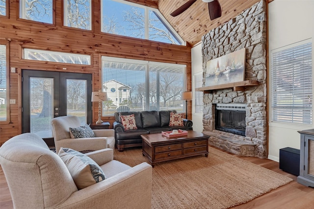 living room with high vaulted ceiling, wooden walls, hardwood / wood-style flooring, wood ceiling, and french doors