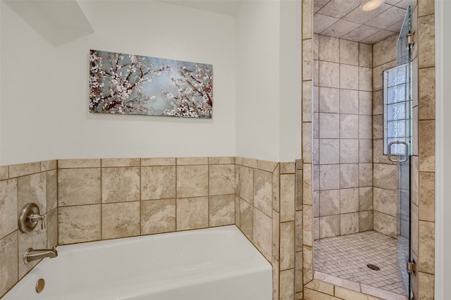 bathroom featuring shower with separate bathtub