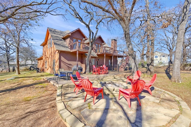 rear view of property featuring a yard, a patio, and a balcony