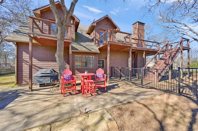 rear view of property with a balcony and a patio area