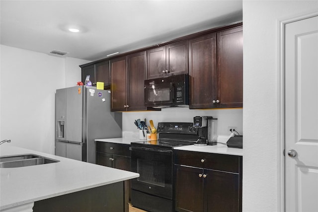 kitchen featuring sink, dark brown cabinetry, black appliances, and a center island