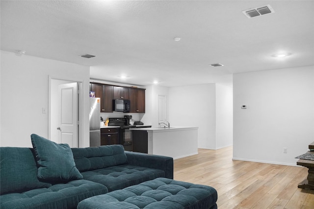 living room with sink and light wood-type flooring