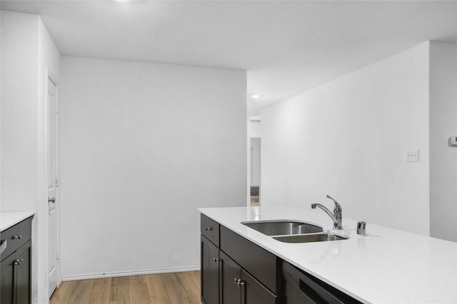 kitchen featuring sink, dishwasher, dark brown cabinetry, and light hardwood / wood-style floors