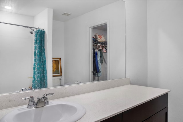 bathroom featuring vanity and a shower with shower curtain