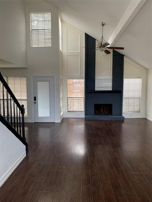 unfurnished living room featuring ceiling fan, dark hardwood / wood-style flooring, high vaulted ceiling, and a brick fireplace