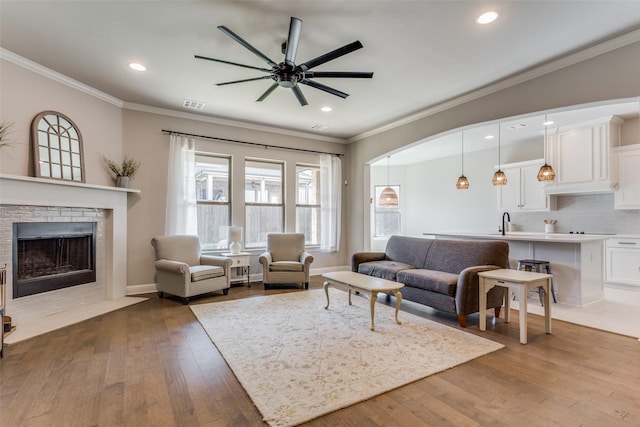 living room with ceiling fan, ornamental molding, and hardwood / wood-style floors