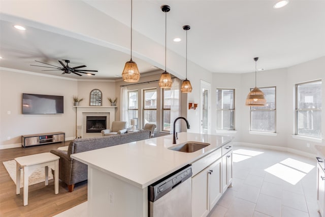 kitchen featuring white cabinets, decorative light fixtures, sink, a kitchen island with sink, and stainless steel dishwasher