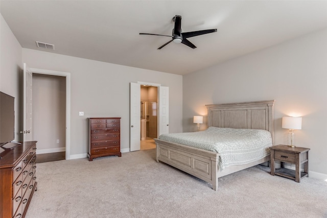 bedroom with light carpet, ceiling fan, and ensuite bathroom